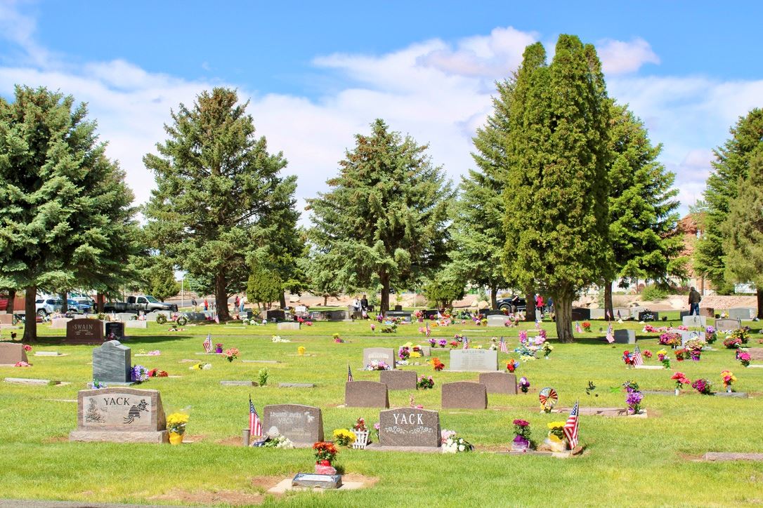 Image of decorated headstones and green grass on Memorial Day 