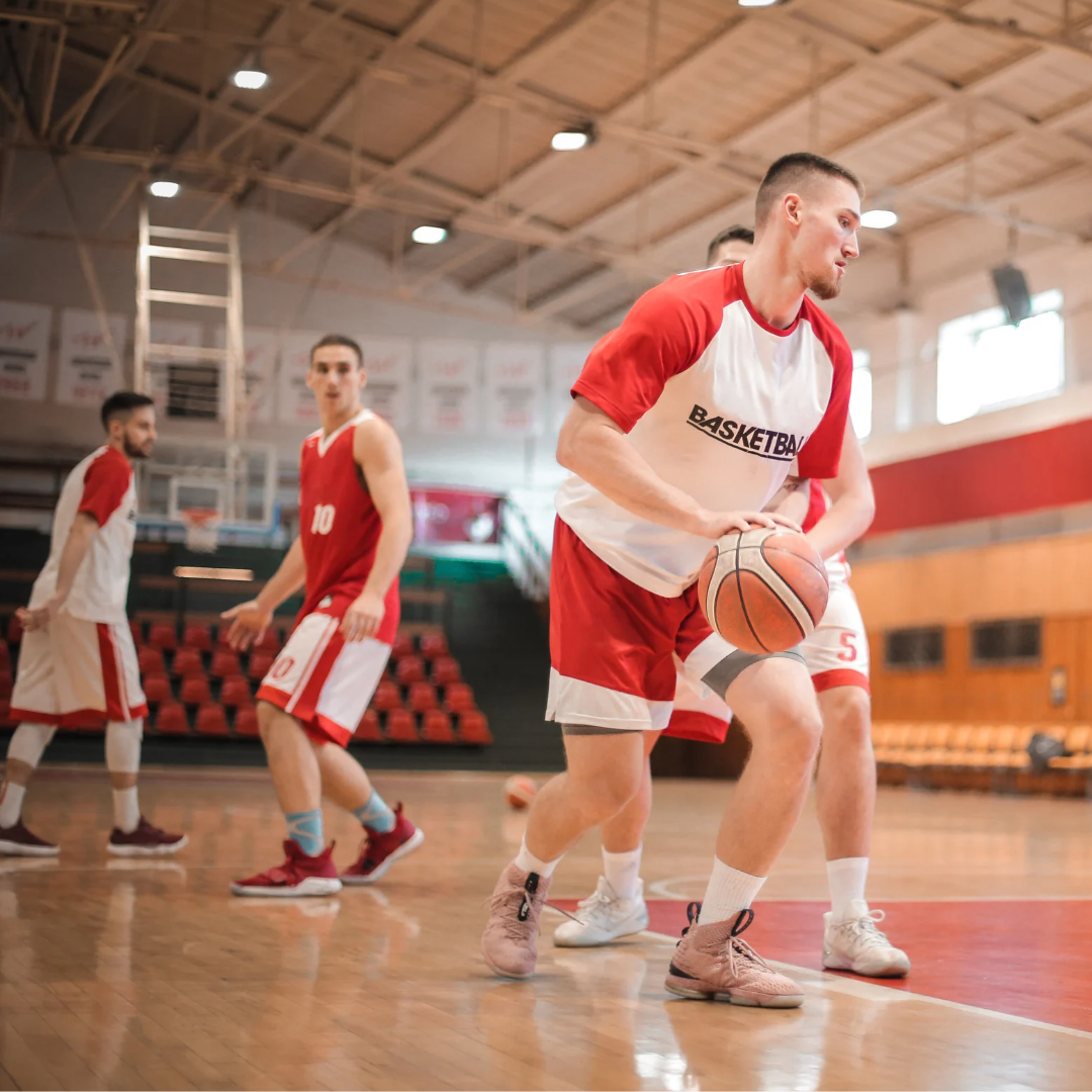 Men playing basketball indoors 