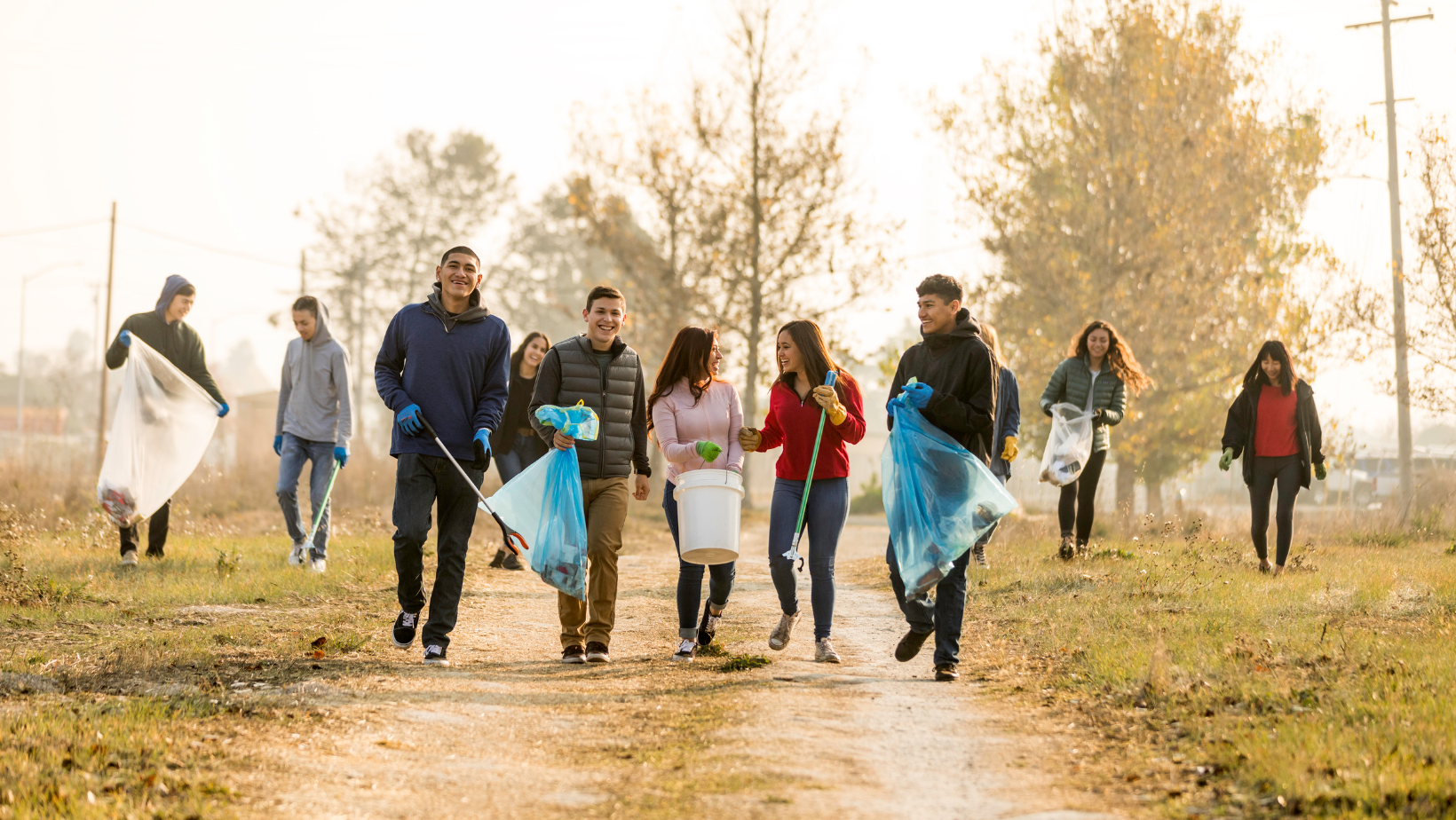 Several young people with buckets, garbage bags and other cleaning tools
