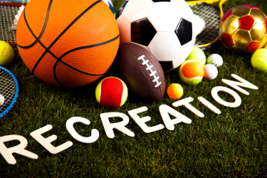 Sports balls on grass with letters spelling out 